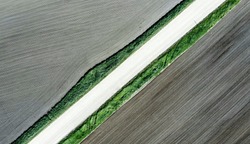 Shot of the field from drone. Farmers field. Road between fields. Background or texture