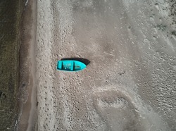 Blue fishing boat seen from above