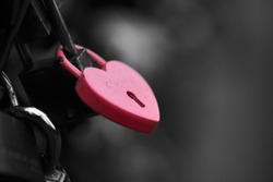 The red heart shape padlock hanging in the middle of many blurred padlocks that around and all are at the fence of the bridge in Paris, France. Concept Padlocks Love forever. Valentine.