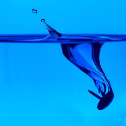 water drop splash in a glass blue colored.