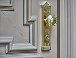 stainless door knob or handle on wooden door in beautiful lighting.