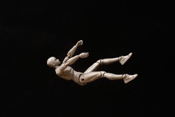 Business and design concept - falling mannequin isolated on black background. falling man
