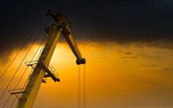 Yellow crane in cargo port translating coal. Industrial scene