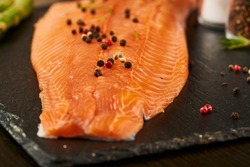 Salmon with black pepper on plate close up.