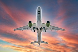 Commercial airplane jetliner flying above dramatic clouds in beautiful sunset light. flight travel transport airline background concept. Airplane in the sunset sky