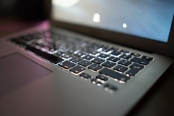 Close up of laptop keyboard colorful neon illumination, backlit keyboard.