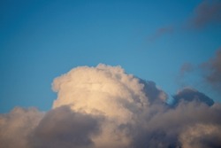 Puffy white cloud on clear blue sky