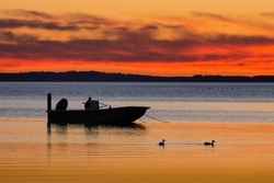 Moored skiff against sunset sky in the calm waters of Currituck Sound in North Carolina's Outer Banks