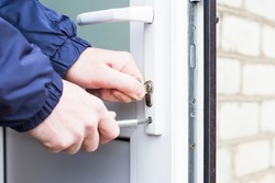Handyman installing door lock in front door. Checking the door lock for operability.