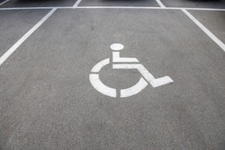 disabled parking sign on dark asphalt