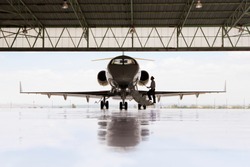 Silhouette of pilot boarding private jet in hangar