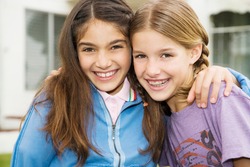 Two young friends embracing and smiling