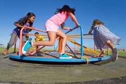 Children having fun riding a carousel in a park