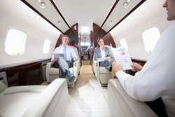 Business employees having a meeting while sitting in a private jet