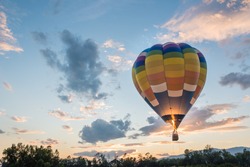 hot air balloon is flying at sunrise