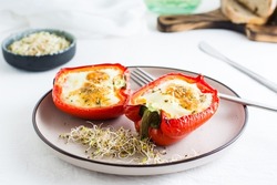 Bell pepper halves baked with egg and microgreens on a plate on the table. Flexitarian organic diet