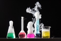 Glass in a chemical laboratory filled with colored liquid during the reaction - studio shoot