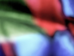 Defocused background image of a multicoloured fabric. 