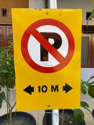 Warning signs are prohibited from parking in a radius of 10 meters around here.  The board is yellow.