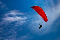 One paraglider is flying in the blue sky. Paragliding on a sunny day.