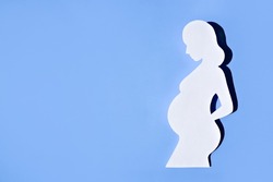 Banner about pregnancy and motherhood. Silhouette of a young pregnant woman on a blue background. Flat styling, space for text.