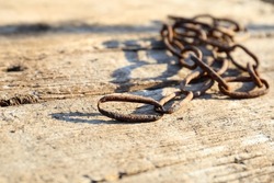 Rusty chain on vintage wooden background. Chain of shackling
