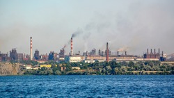 Smokestacks of industrial plants, view from the water
