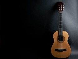 Acoustic guitar on a black background (with copy space)