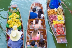 Tourists visiting by boat at Damnoen Saduak floating market in Ratchaburi near Bangkok, Thailand