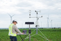 Engineer using tablet computer collect data with meteorological instrument to measure the wind speed, temperature and humidity and solar cell system on corn field, Smart agriculture technology concept