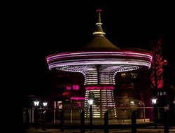 Long exposure of a beautiful spinning carousel (merry-go-round) late evening in a park showing light trails