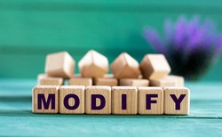 MODIFY - word on wooden cubes on a green background with lavender. Business concept