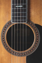 Closeup photo of the strings and sound hole of a classical guitar