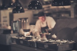 Blurred Restaurant chef: Chef cooking in the open kitchen, customer can see they cooking at food counter