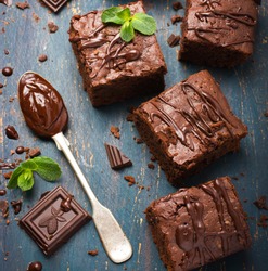 homemade chocolate brownies on dark background, top view