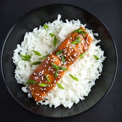 teriyaki salmon and  rice, served with sesame seeds and chopped green onions, top view.