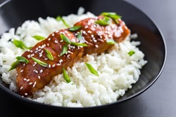 teriyaki salmon and  rice, served with sesame seeds and chopped green onions, selective focus.