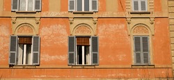 Rome, downtown of the city. Windows with very unusual moldings decorating the upper section.