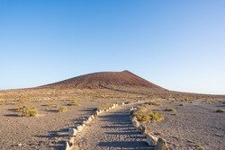 Sandy pathway leading to the volcanic red mountain Montaña Roja close to El Médano in south Tenerife.
