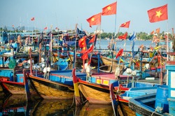 several Fishing boats with red flags in marina at Nha Trang, Vietnam