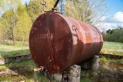 Couple of old rusty abandoned disel tanks in the forest. Text translation 