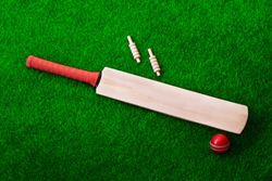 cricket bat and ball place on cricket ground pitch, green grass