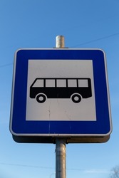Bus stop sign with blue sky in the background