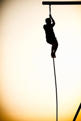 Silhouette of a person climbing a rope on the beach, Santa Monica Beach, Santa Monica, Los Angeles County, California, USA
