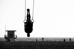 Silhouette of a person swinging on rings on the beach, Santa Monica Beach, Santa Monica, Los Angeles County, California, USA
