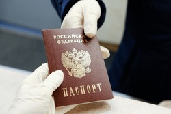 Сlose-up hands in latex gloves pass the Russian national passport to each other at hotel during pandemiс