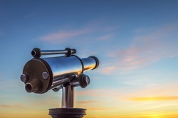 Monocular telescope at sunset with a cloudy sky