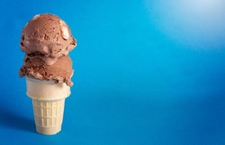 A Chocolate Rocky Road Ice Cream Cone on a Blue Background