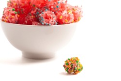 A Freeze Dried Sweet and Tangy Candy with Small Candies on the Outside of a Chewy Center on a White Background