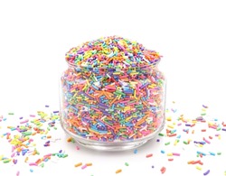 Small sugar candies rainbow in glass jar. Sweet treats for garnishing, donuts, and cakes at birthday parties. isolated on a white background